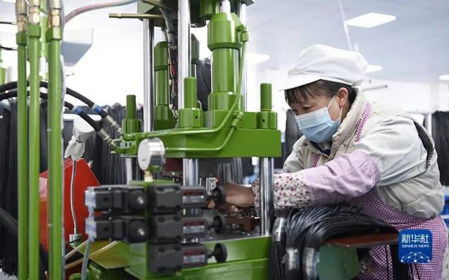 2月8日,村民在康乐县一家乡村就业工厂电子器件生产线上工作.